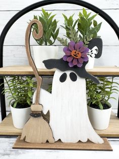 a wooden shelf with plants and decorations on it