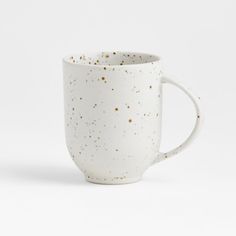 a white coffee cup with gold speckles on the outside and inside, sitting in front of a white background