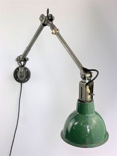 an old fashioned green lamp on a white wall