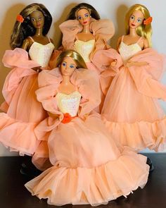 five barbie dolls in pink dresses standing next to each other