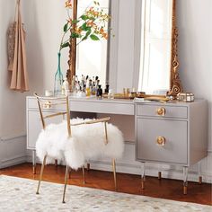 a vanity with a chair and mirror in a room