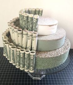 stacks of money are stacked on top of each other in front of a round cake