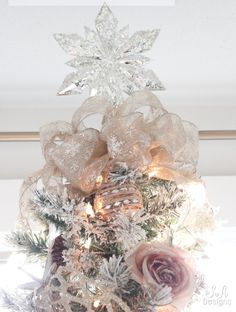 a white christmas tree decorated with bows and lights