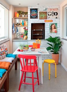 a small room with two chairs and a table in front of a fire place on the wall