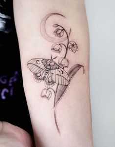 a tattoo with a butterfly on it's arm and flowers in the middle,