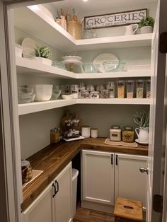 an open pantry with white cabinets and wooden counter tops