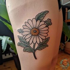 a woman's thigh with a flower tattoo on it