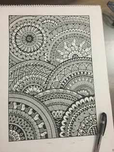 a drawing on top of a white paper next to a pen