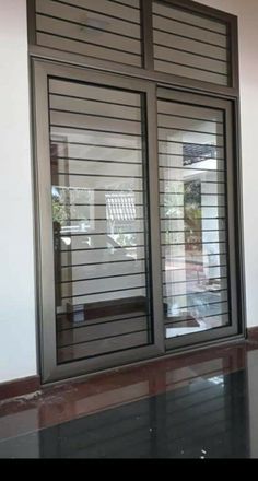 an open sliding glass door with blinds on the outside and inside windows that are closed to let in light