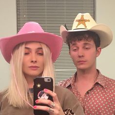 a man and woman in cowboy hats are taking a selfie with their cell phone