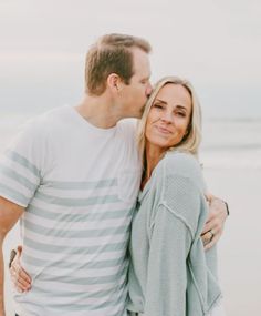 a man and woman kissing on the beach