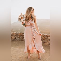 a woman in a pink dress holding flowers