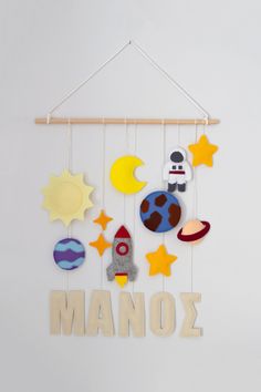 a mobile with the word manoz hanging from it's side and various objects attached to it