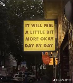 a yellow sign that says it will feel a little bit more okay day by day