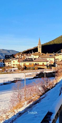 a snow covered field with buildings in the background