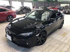 a black car parked in a garage next to other cars