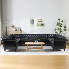 a black leather couch sitting on top of a hard wood floor next to a coffee table