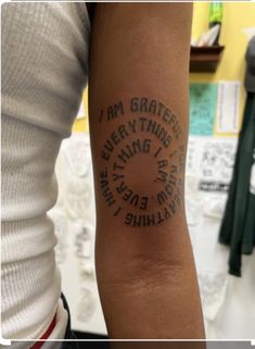 a person with a tattoo on their arm that says i am grateful everything is going to happen