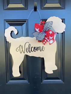 a welcome sign with a dog on it hanging from the front door to greet someone