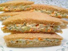 three sandwiches stacked on top of each other on a white and blue plate with floral designs