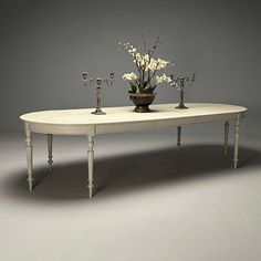 a white table with flowers and candles on it