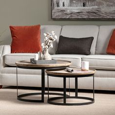 two coffee tables sitting in front of a couch