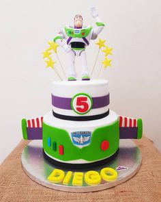 a toy story birthday cake with buzz lightyear on top and stars around the base