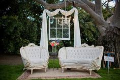 an old fashioned couch and loveseat are set up in the yard for a wedding ceremony