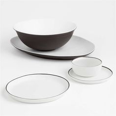 black and white dinnerware set with matching saucer, bowl and plate in the middle