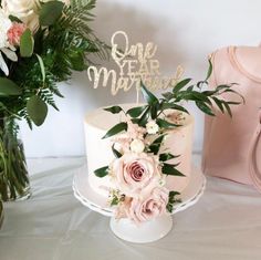 there is a cake with flowers on it and a pink purse next to the cake