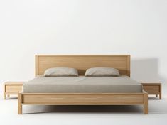 a bed with two night stands next to it and a white wall in the background