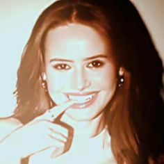 a young woman brushing her teeth with an electric toothbrush