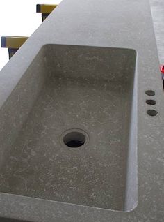 the sink is made out of concrete and has holes in it