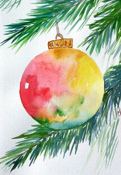 a watercolor christmas ornament hanging from a pine tree