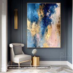 an abstract painting hangs on the wall next to a chair and vase with flowers in it