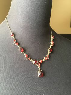 "Here is a red crystal necklace with rhinestones in a glamorous shade of ruby. The stones are prong set and they are well complimented by the antiqued gold tone settings. This is a very well made signed vintage piece in excellent condition. It is signed NW and Avon on an oval cartouche. It is 17 1/2\" long and has a 3 1/2\" extender chain. Please see this section of my shop for more vintage costume jewelry: https://www.etsy.com/shop/ChrisandTine?section_id=17309162 My full shop: http://www.chris Elegant Red Rhinestone Necklaces, Red Rhinestone Evening Necklaces, Red Rhinestone Evening Necklace, Red Necklaces With Sparkling Stones For Formal Occasions, Red Formal Necklace With Sparkling Stones, Red Rhinestone Necklaces For Evening, Red Necklace With Sparkling Stones For Formal Occasions, Red Sparkling Stones Necklace For Formal Occasions, Elegant Red Jeweled Necklace