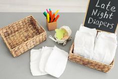 a table topped with napkins and baskets next to a chalkboard that says late night diapers