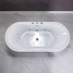 a white bath tub sitting on top of a marble counter