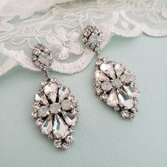 Hollywood Glam crystal earrings, made with top Swarovski rhinestones hand sett on silver filigree drop . finished with hypo allergenic surgical steal ear wire. Original design , hand crafted by me in my studio. Light weigh and very comfortable to wear . Other related accessories are coming soon ( necklace) Suggested Bracelet: https://www.etsy.com/listing/721178495/white-opal-wedding-cuff-bracelet-crystal?ref=shop_home_active_7 Please contact me if you have any questions. White Crystal Chandelier Earrings With Rhinestones, Dazzling White Crystal Dangle Earrings, Dazzling White Dangle Crystal Earrings, White Jeweled Bridal Earrings Gift, White Teardrop Crystal Earrings, Crystal Jeweled Bridal Earrings For Wedding, White Crystal Embellished Wedding Earrings, White Crystal Rhinestone Teardrop Earrings, White Chandelier Earrings For Wedding With Sparkling Stones