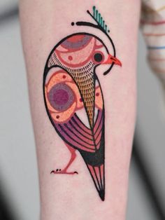 a colorful bird tattoo on the arm