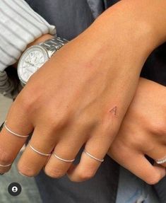 two people with matching rings on their hands, one holding the other's hand