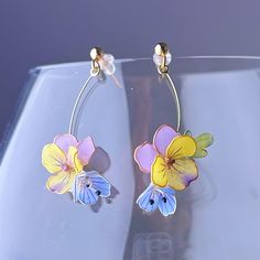 Handmade Yellow and Purple Pansy Spring Garden Flowers Earrings Add a touch of vibrant colour to your outfit with these Handmade Yellow and Purple Pansy Spring Garden Flowers Earrings. Perfect for spring and summer, these earrings feature a beautiful pansy flower design that will surely make a statement. They also make a great gift for any flower lover. As a gift shop, we offer a complimentary gift box for every order. Some details - Size of flower: around 10mm x 12mm; - Length of drop: around 3 Spring 3d Flowers Dangle Earrings, Elegant Spring Flower Earrings With Floral Print, Elegant Floral Print Flower Earrings For Spring, Whimsical Flower Earrings For Spring, Spring Multicolor Flower Earrings, Whimsical Spring Earrings With Flower Charm, Whimsical Spring Flower Earrings, Spring Floral Print Flower Earrings, Colorful Flower Earrings For Spring