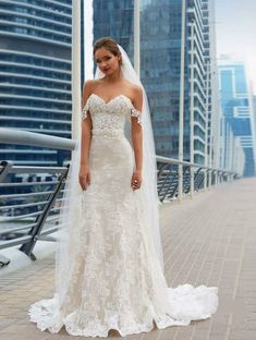 a woman in a wedding dress posing for the camera