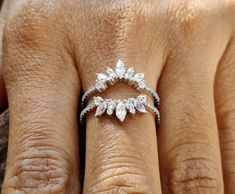 a woman's hand with a diamond ring on top of her finger and an engagement band