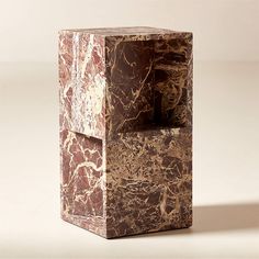 a brown and white cube shaped object sitting on top of a table next to a wall