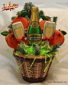 a bottle of champagne in a wicker basket filled with oranges and greenery