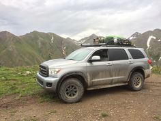 a silver truck parked on top of a dirt road