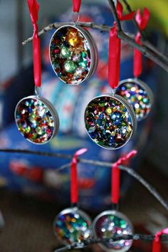 some ornaments are hanging from a tree with red candles and streamers on them,