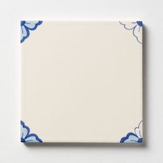 a blue and white tile with clouds on the border is shown in front of a white background