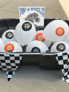 white balloons with black and orange designs in a box